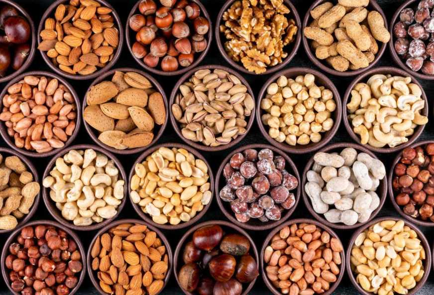 Vitamin B12 Rich Dry Fruits (pecan-pistachios-almond-peanut-cashew-pine-nuts-lined-up-assorted-nuts-dried-fruits-mini-different-bowls)